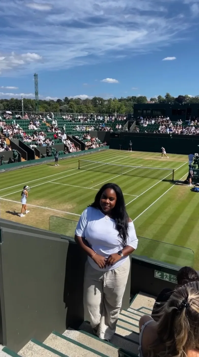 Janita standing courtside on the grass at Wimbledon