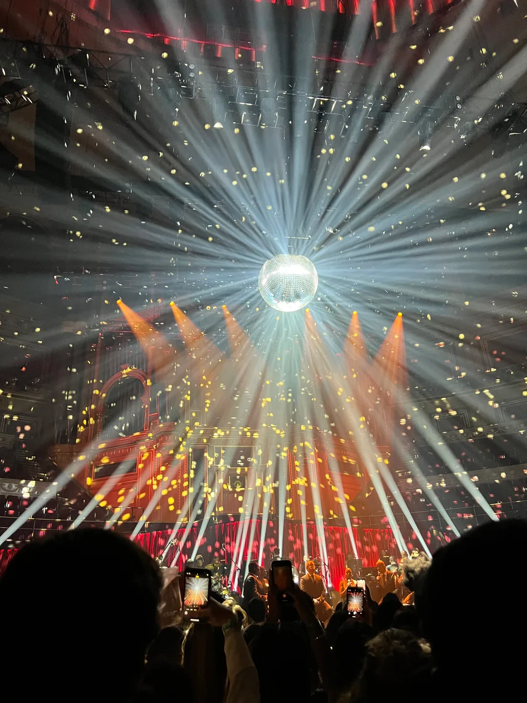 Light beams and confetti over a concert crowd